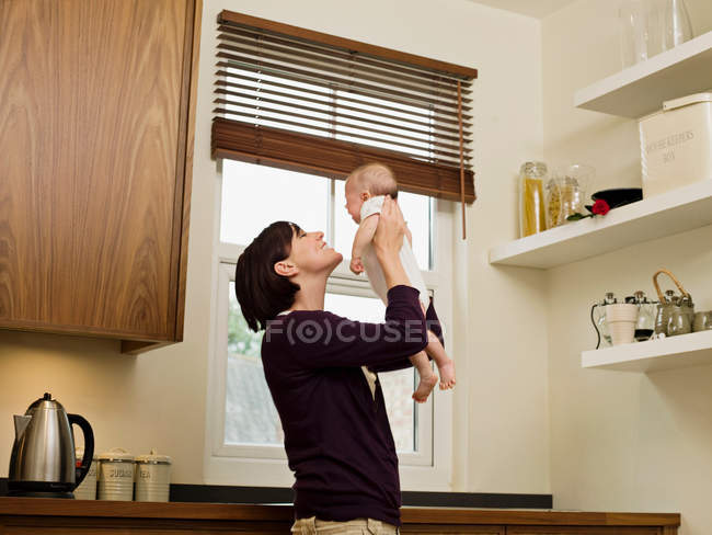 Mãe segurando seu bebê no ar — Fotografia de Stock