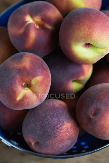 Close up of peaches pile in colander — Stock Photo