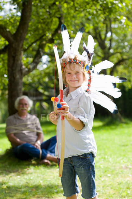 Disguised boy with toy bow and arrows — Stock Photo