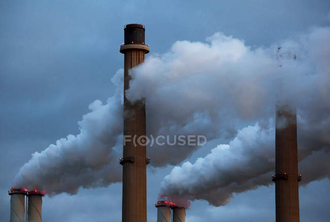 Fumée coulant des cheminées d'usine — Photo de stock