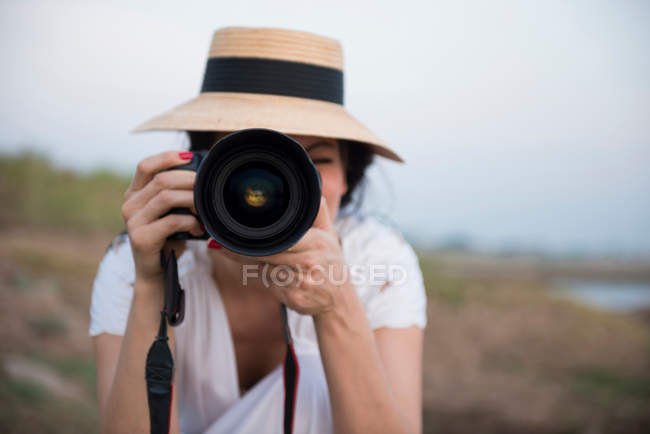 Женщина в шляпе фотографирует — стоковое фото