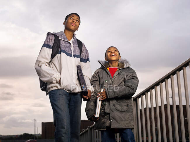 Deux garçons marchant avec des ordinateurs portables — Photo de stock