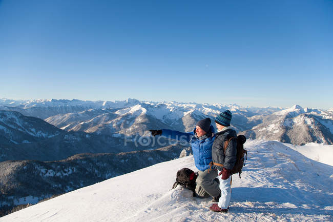 Padre e hijo examinando el paisaje nevado - foto de stock