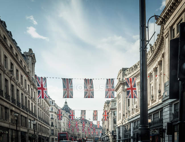 Banderas británicas colgando sobre la calle de la ciudad - foto de stock