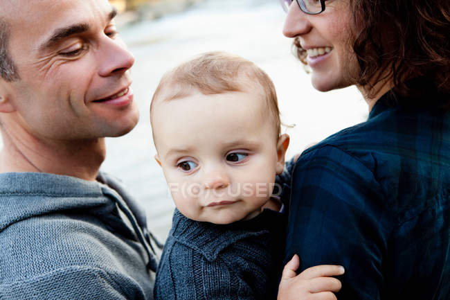 Усміхнені батьки тримають дитину — стокове фото