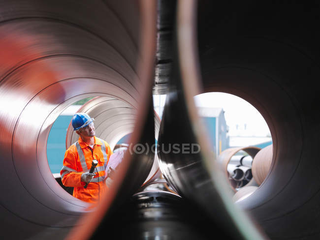 Uomo che controlla i tubi in fabbrica — Foto stock
