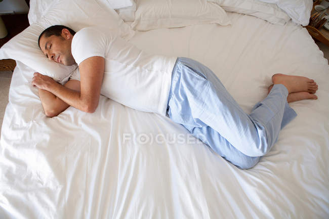 Homem dormindo na cama em casa — Fotografia de Stock