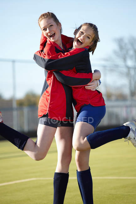 Team members hugging on field — Stock Photo