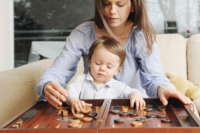 Madre e hijo jugando backgammon - foto de stock