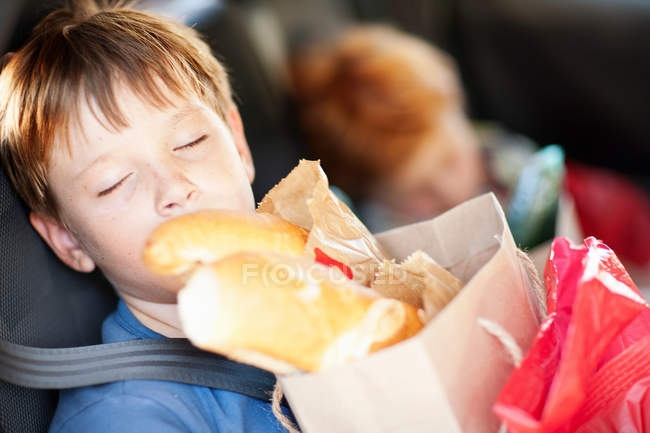Boy with bag sleeping in backseat — Stock Photo