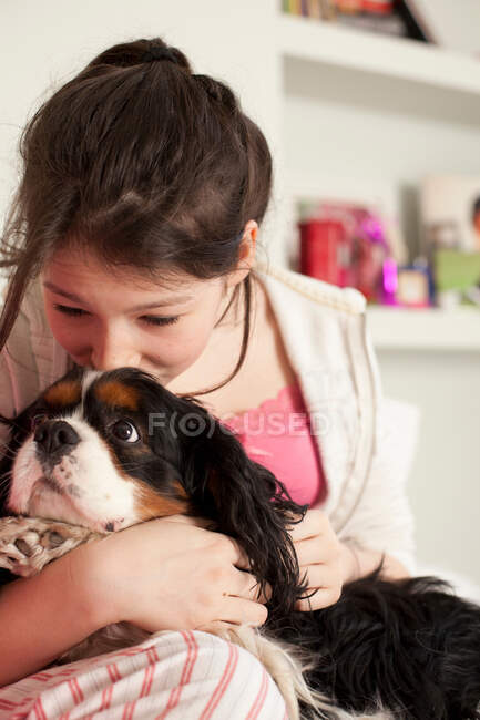 Teenage girls playing with dog at home — Stock Photo