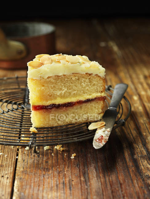 Sherry trifle cake slice with knife on cooling rack — Stock Photo