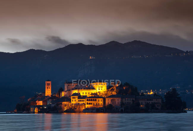Village buildings on island lit up at night — Stock Photo
