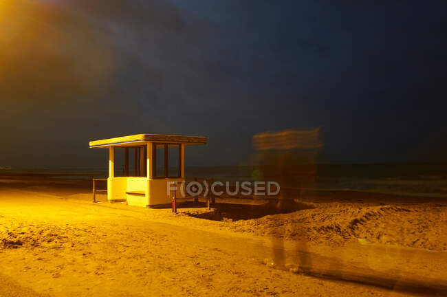 Time lapse vista del hombre en la playa por la noche - foto de stock