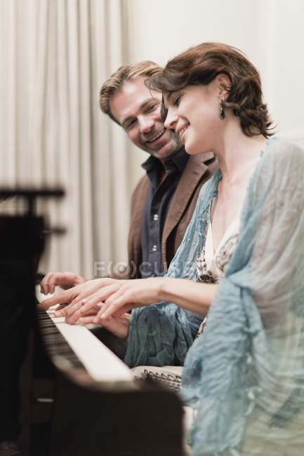Couple playing piano together at home — Stock Photo