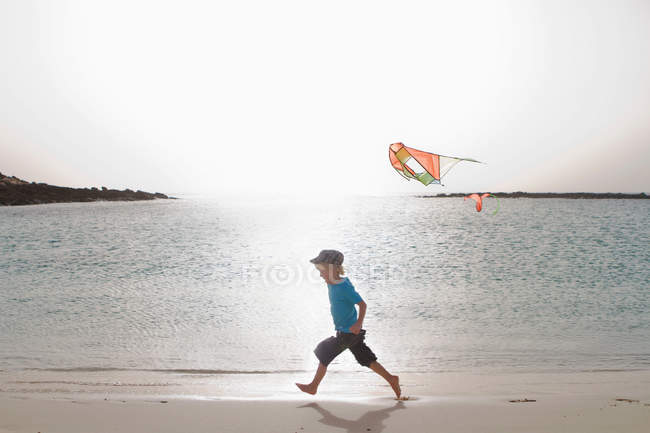 Хлопчик летить змієм на пляжі — стокове фото