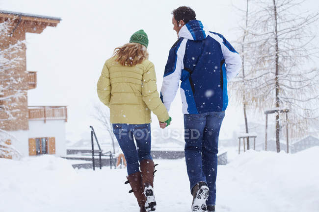 Casal caminhando juntos na neve — Fotografia de Stock