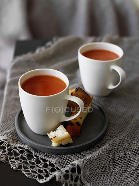 Тарелка хлеба с чашками супа — стоковое фото