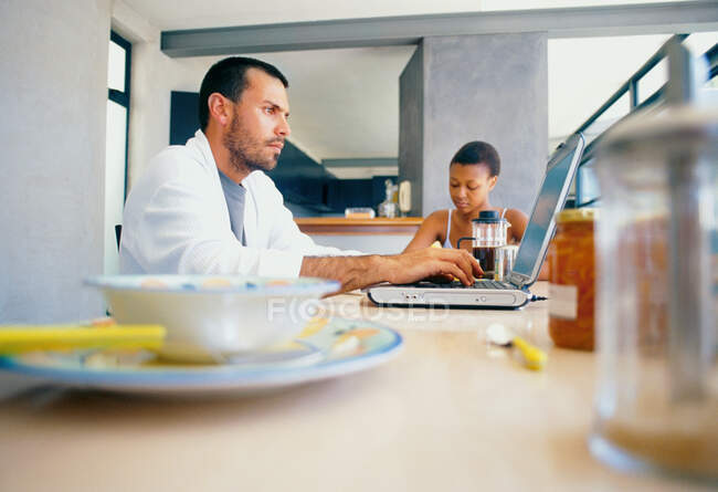 Людина використовує ноутбук за столом для сніданку — стокове фото