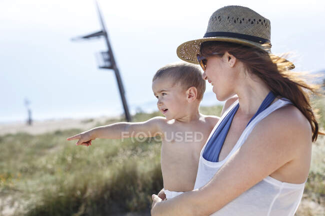 Mother carrying son in arms — Stock Photo