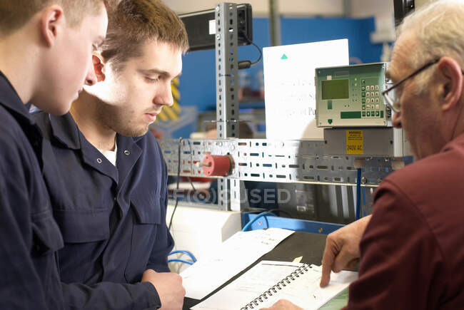 Ingenieros eléctricos trabajando en taller - foto de stock