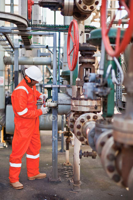 Arbeiter stellt Messgerät in Ölraffinerie ein — Stockfoto