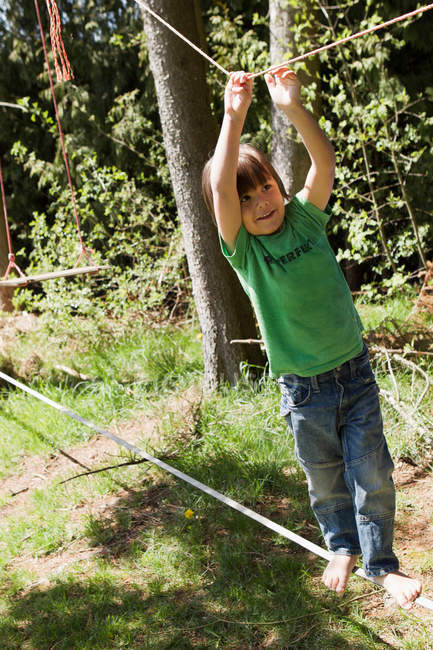 Menino jogando na corda bamba ao ar livre — Fotografia de Stock