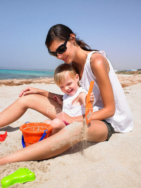 Mujer y niña en la playa - foto de stock