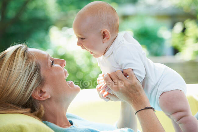 Madre sorridente che gioca con il bambino — Foto stock