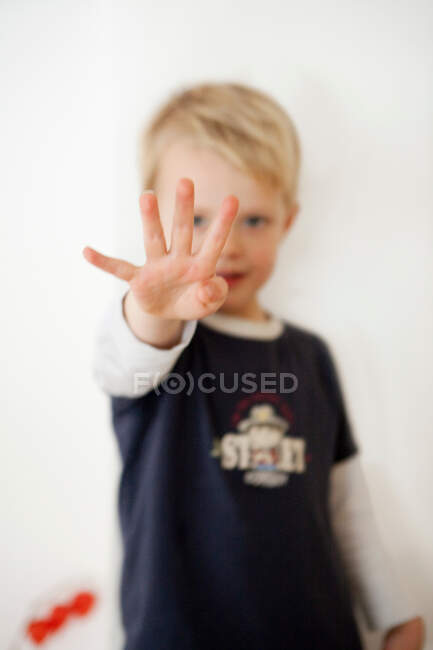 Niño señalando cuatro dedos - foto de stock