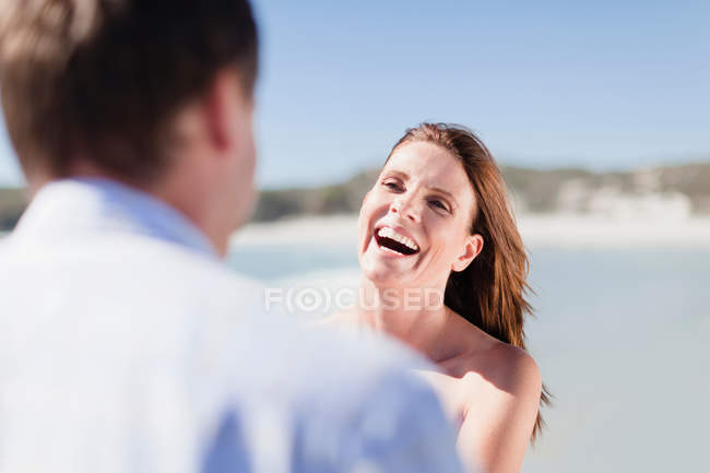 Sonriente pareja caminando en la playa - foto de stock