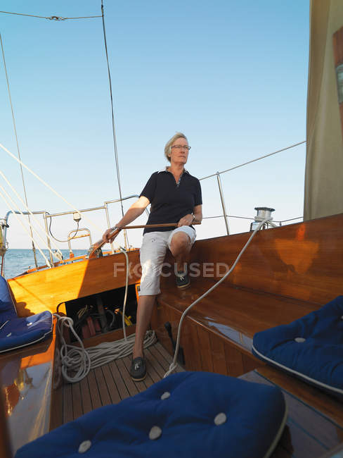 Donna anziana sterzo barca a vela — Foto stock