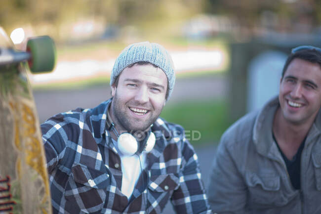 Dos amigos varones con monopatín - foto de stock