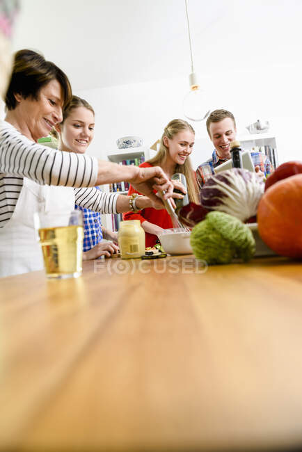 Madre, hijas e hijo preparando la comida - foto de stock