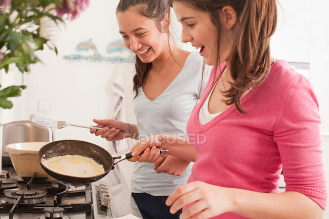 Meninas adolescentes fazendo panquecas — Fotografia de Stock