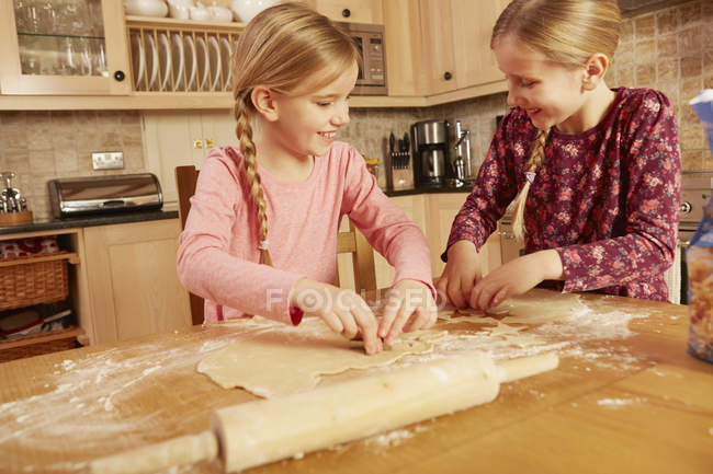 Two girls baking together at kitchen table — Stock Photo
