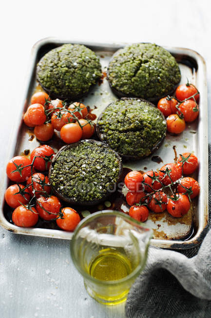 Tomatoes and herbed patties — Stock Photo