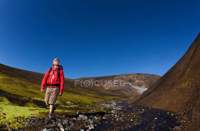 Escursioni uomo in roccioso torrente rurale — Foto stock
