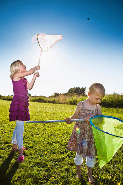 Mädchen spielen mit Schmetterlingsnetzen — Stockfoto