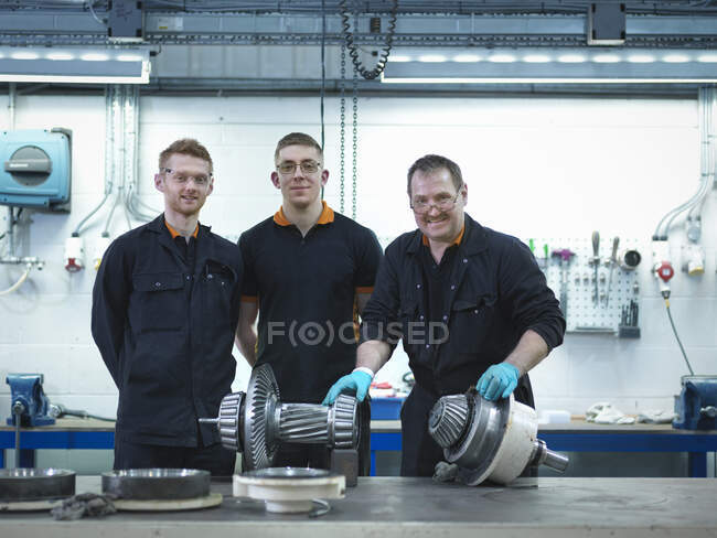 Engineer teaching apprentices in engineering factory, portrait — Stock Photo