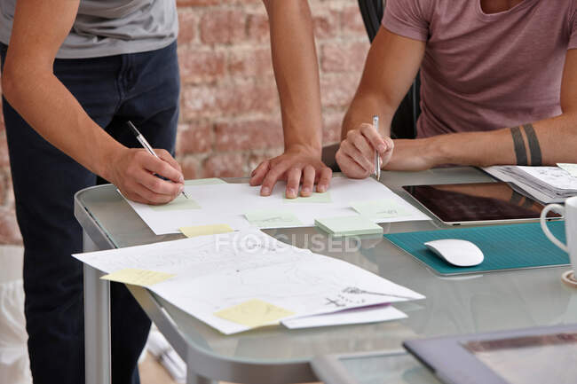Два чоловіки-колеги, один робить нотатки — стокове фото