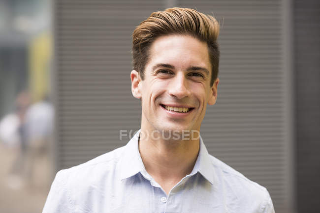 Портрет улыбающегося молодого бизнесмена за пределами офиса, Лондон, Великобритания — стоковое фото