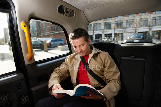 Mann liest in Londoner Taxi — Stockfoto