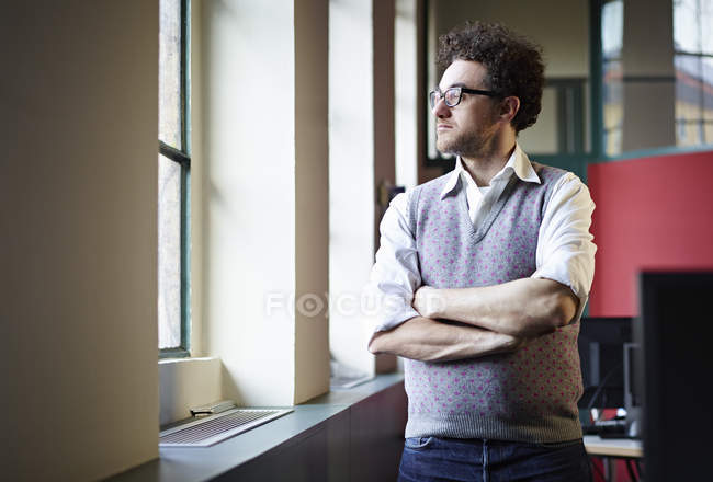 Homem adulto médio olhando pela janela — Fotografia de Stock