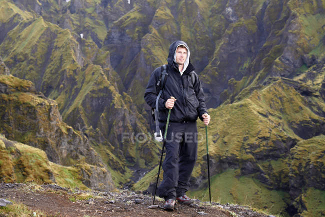 Caminhante em pé na encosta rochosa — Fotografia de Stock