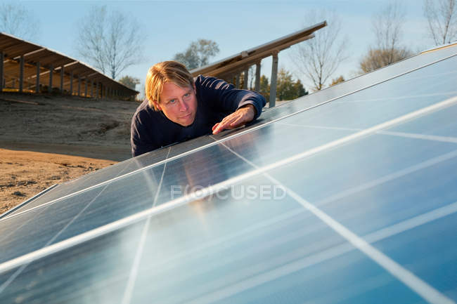 Trabajador examinando paneles solares, enfoque selectivo - foto de stock