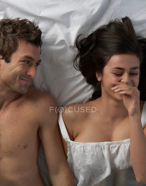 Casal jovem na cama rindo, ângulo alto — Fotografia de Stock