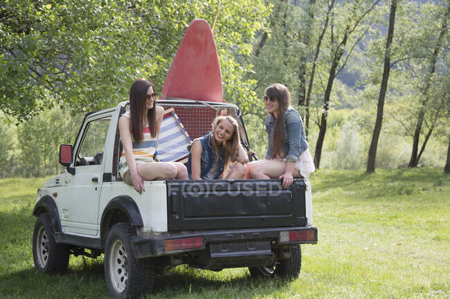 Freunde sitzen auf dem Rücken des Geländewagens — Stockfoto