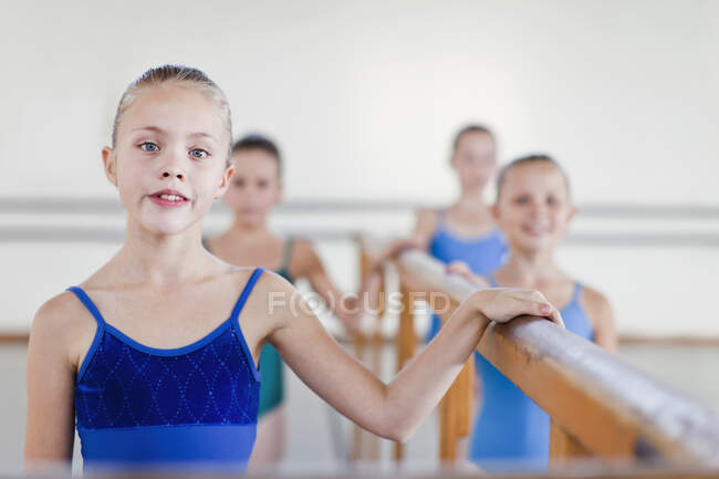 Ballet dancers standing at barre — Stock Photo