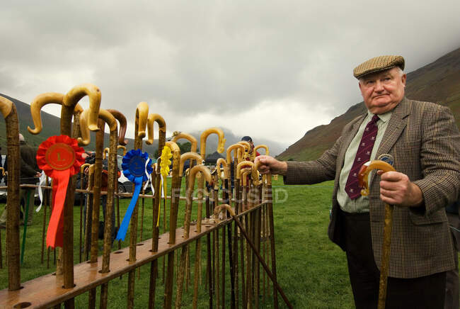 Man holding a walking stick after prize giving — Stock Photo